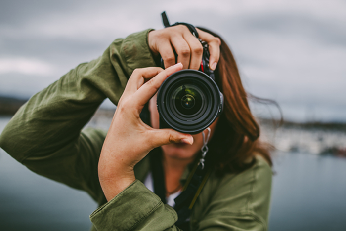 Une femme prend une photo avec une caméra